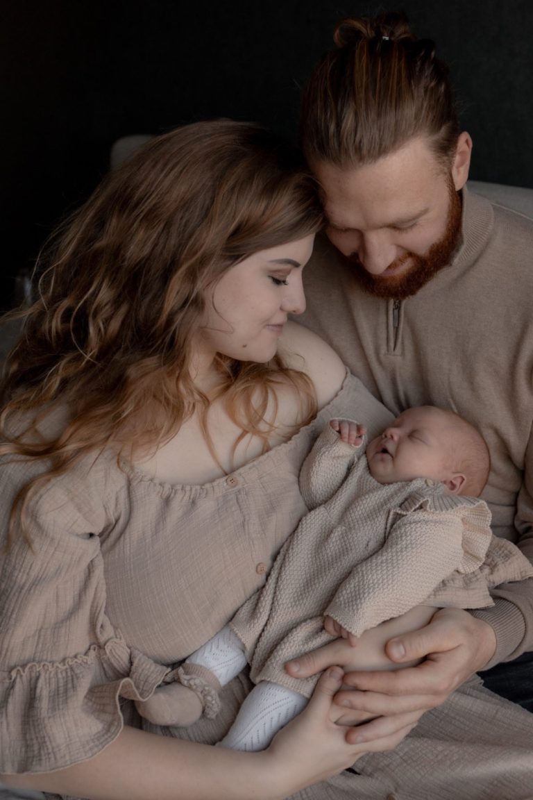 Vader kust een slapende baby vastgehouden in zijn armen, beide met eenvoudige kleding.